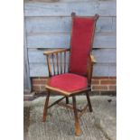 A polished as walnut spindle back elbow chair, upholstered in a red fabric, on turned supports