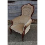 A Victorian walnut showframe armchair, upholstered in a mushroom velour, on cabriole supports