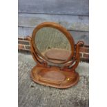 An oval swing frame toilet mirror with plateau base, fitted jewel compartment, 24" wide x 27" high