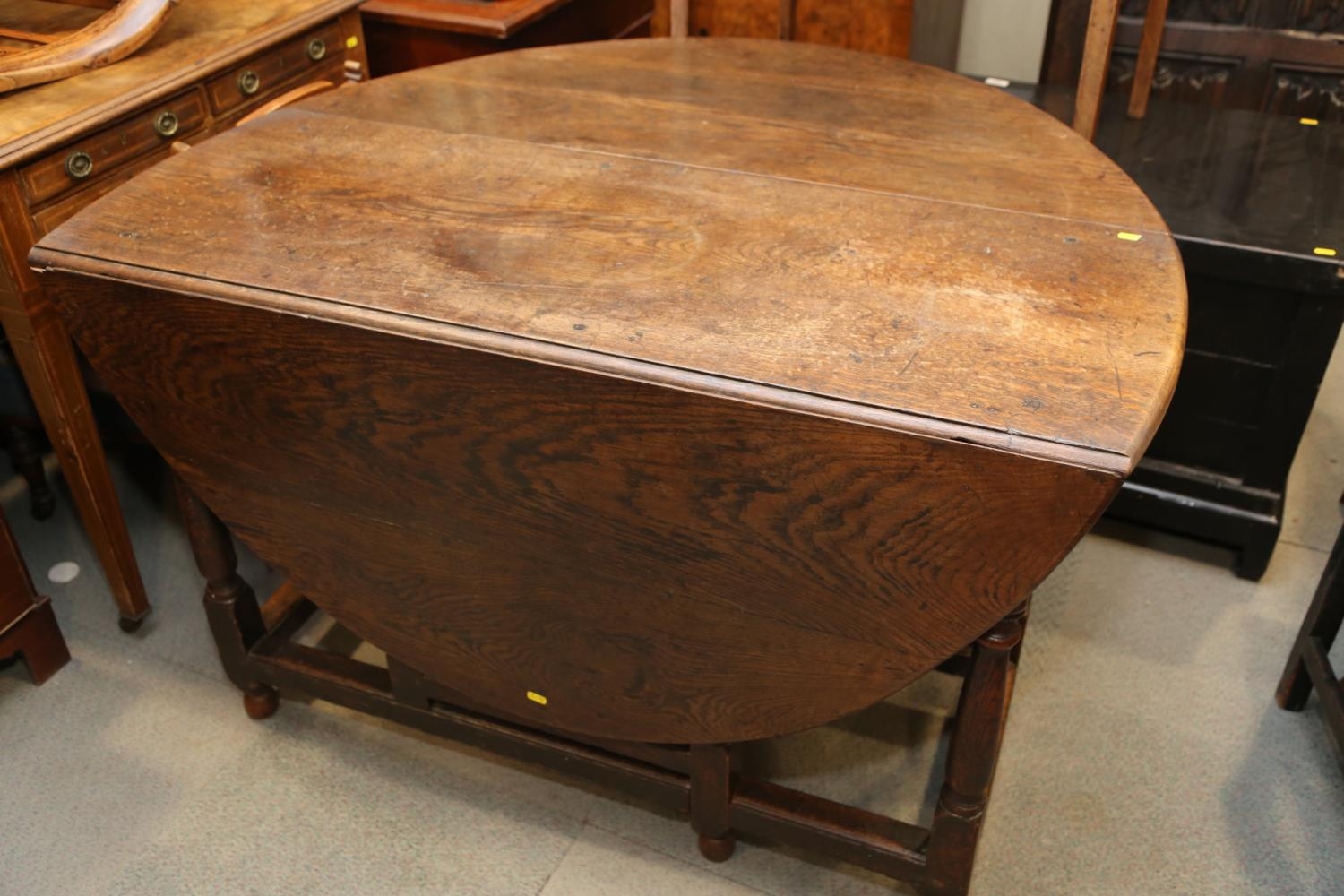 A 19th century oak oval gate leg dining table, on turned and stretchered supports, 48" wide x 62 1/