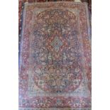 An antique Persian rug with central medallion on a blue floral ground and multi-borders in shades of