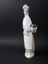A Lladro figure of a girl with a basket of fruit, 14" high, and a 1960s German porcelain vase with