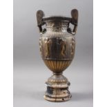 An anodised brass urn with relief Greek classical decoration, on turned wooden base, 14 1/4" high