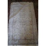 A Qum silk rug with all-over garden design in shades of cream, blue, green and red, signed, 72" x