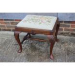 A walnut stool of early Georgian design with needlepoint drop-in seat, on cabriole stretchered