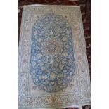 A Kashan wool and part silk pile rug with star medallion and flower design on a blue ground and