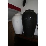 A white painted papier-mache baluster urn, 31" high, and a similar black painted urn