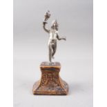 A cast white metal figure of a putto holding a covered goblet, on Florentine carved hardwood
