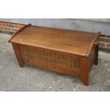 An oak coffer of early 17th century design with shaped top and arcaded front, 41" wide x 18" deep