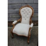 A gentleman's Victorian carved walnut showframe elbow chair and lady's matching chair, upholstered