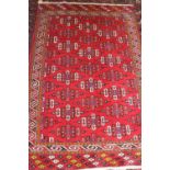 A Caucasian rug with shaped guls, on a red ground and multi-geometric borders, 75" x 51" approx