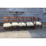 A set of five early 19th century mahogany and satinwood oval lozenge inlaid bar back dining chairs