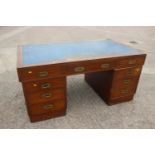 A 1930s walnut double pedestal desk, fitted with military style handles, drawers and blue tooled