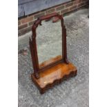 A burr walnut swing frame toilet mirror of Queen Anne design, on plateau base, fitted two drawers,