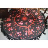 A Casa Pupo rug with animal design in shades of red, black and pink, 60" dia