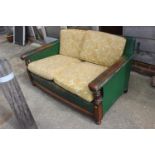 A 1930s oak two-seat settee, upholstered in a green leather, 54" wide