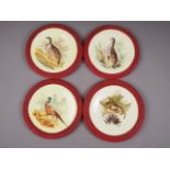 A set of four French game bird and hare decorated plates, in woven rattan mounts