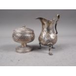 A Georgian silver cream jug with embossed decoration, 2oz troy approx, and a Middle Eastern pedestal