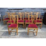 A set of twelve oak dining chairs of Georgian design with drop-in seats and pierced splat backs (