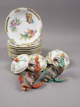 A collection of Herend "Queen Victoria" pattern saucers and chocolate cup covers, two Herend dolphin