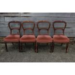 A set of four hoop back dining chairs with stuffed over seats, upholstered in a salmon pink