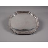 An octagonal silver salver, on four scrolled supports, 20.9oz troy approx