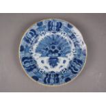 An 18th century Delft shallow bowl with vase of flowers decoration, 12" dia (rim chips)