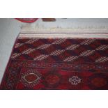 A Bokhara rug of traditional design with seventy-five medallions and multi-borders, 112" x 73"