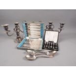 A pair of silver plated three-branch candelabra, two cased sets of plated cutlery and three plated