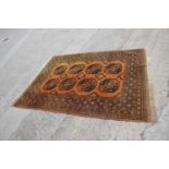 A Kayam contemporary gold wash rug with eight central guls and multi-borders on an orange and