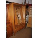 A pair of Ercol light oak wardrobes enclosed panel doors with fitted interior mirror over one long