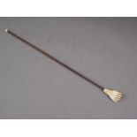 A 19th century carved ivory hand back-scratcher with palm wood stem, 17 1/2" long