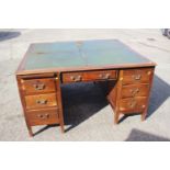 A partners early 20th century walnut double pedestal desk with green leather top (for