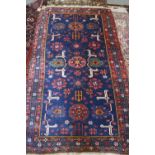 A Kuba rug with three medallions, candelabra and stylised birds on a dark blue ground and triple-