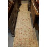 A Persian design runner with all-over scroll design on a cream ground, 117" x 30" approx