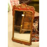 A Georgian wall mirror, in red and gilt frame decorated shells and scrolls, 19 3/4" x 12"