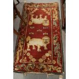A Tibetan? rug with lion design on a red ground, 59" x 34" approx (moth damage)