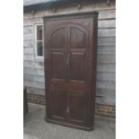 An 18th century provincial oak corner cupboard, the shaped interior enclosed two arch top doors over