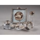 A pair of silver napkin rings, a white metal topped sugar sifter, a white metal and cut glass