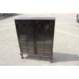 A mahogany display cabinet, fitted adjustable shelves enclosed Gothic lattice glazed doors, on