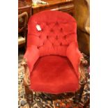 A 19th century carved mahogany spoon back armchair, button upholstered in a red velour, on turned
