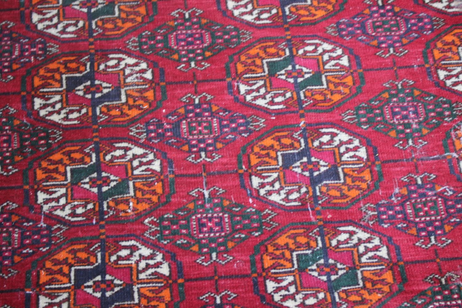 A Bokhara rug with thirty-three guls on a red ground with multi-borders in shades of green, orange - Bild 3 aus 4