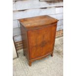 A figured walnut and banded bowfront cupboard enclosed one door, on splay supports, 25 1/2" wide x