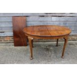 An early 20th century walnut oval extending dining table with extra leaf, 70" x 40" x 29 1/2"