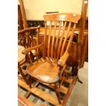 A Windsor beech back farmhouse elbow chair with elm panel seat, on turned and stretchered supports