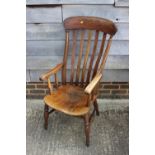 A Windsor lath back elbow chair with scroll arms, on turned and stretchered supports