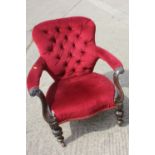 A 19th century carved mahogany open armchair, button upholstered in a red velour, on carved and