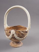 An 18th century pottery basket with swag decoration, on a marbled ground