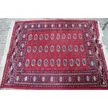 A Bokhara rug of traditional design with thirty guls on a red ground, 66" x 52" approx