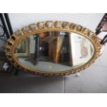 A 19th century oval bevelled wall mirror, in gilt gesso frame, 32" x 22"